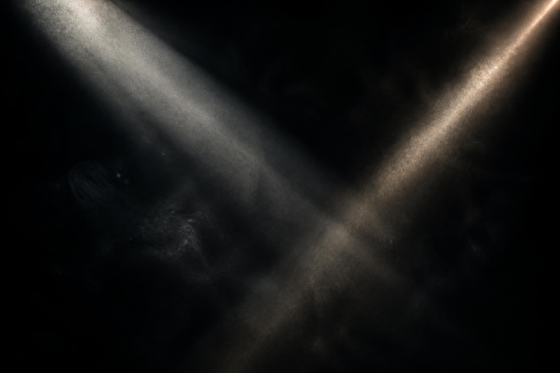 Haces de luz cruzándose en la penumbra
